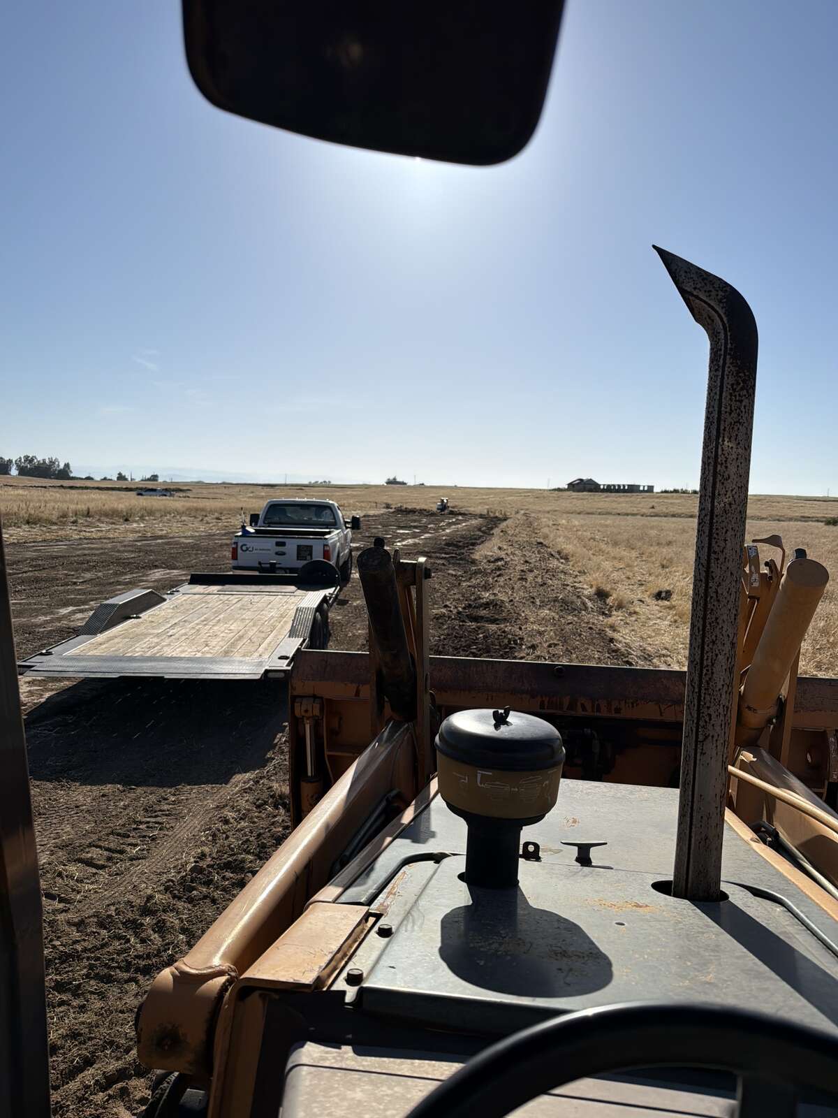 CKJ Ag Services truck and flatbed trailer in the field