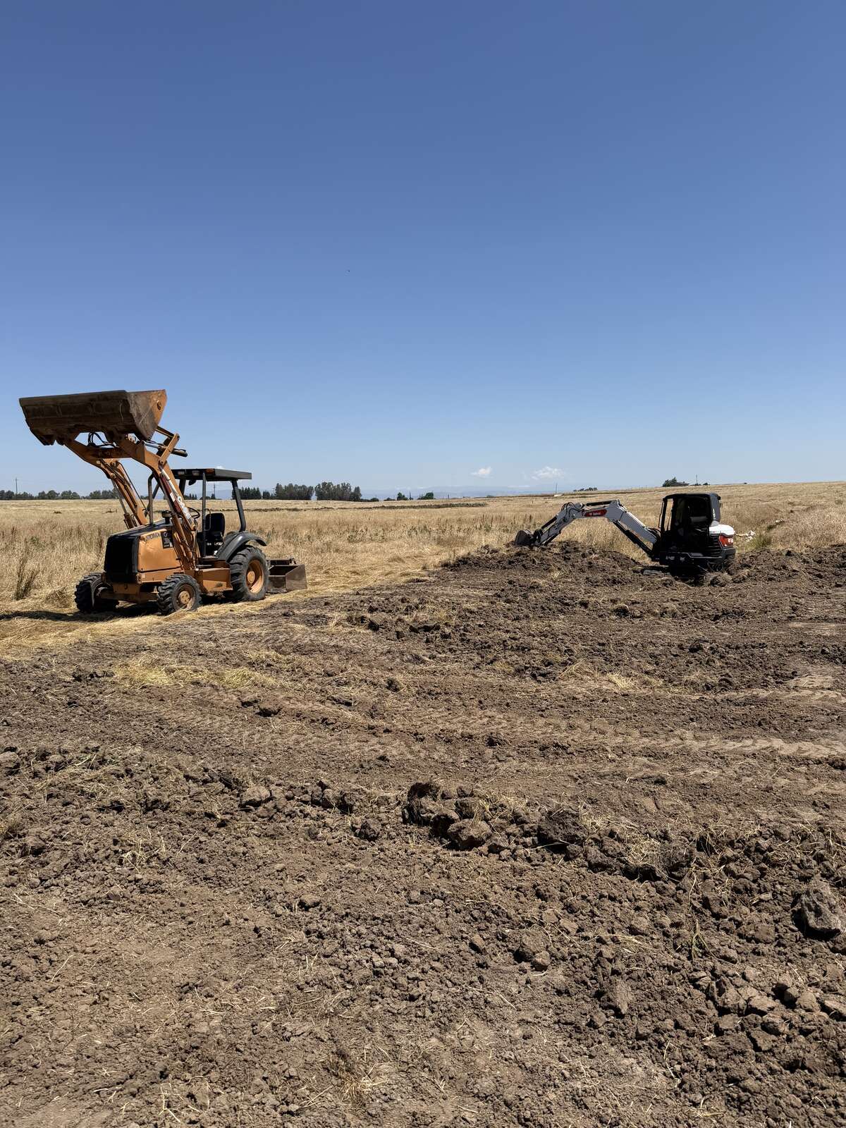 CKJ Ag Services Case loader and Bobcat excavator breaking ground on a Central Valley field